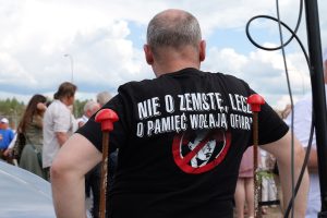 mężczyzna tyłem, na czarnej koszulce napis - nie o zemstę lecz o pamięć wołają ofiary. zdjęcie - domostawa 2025